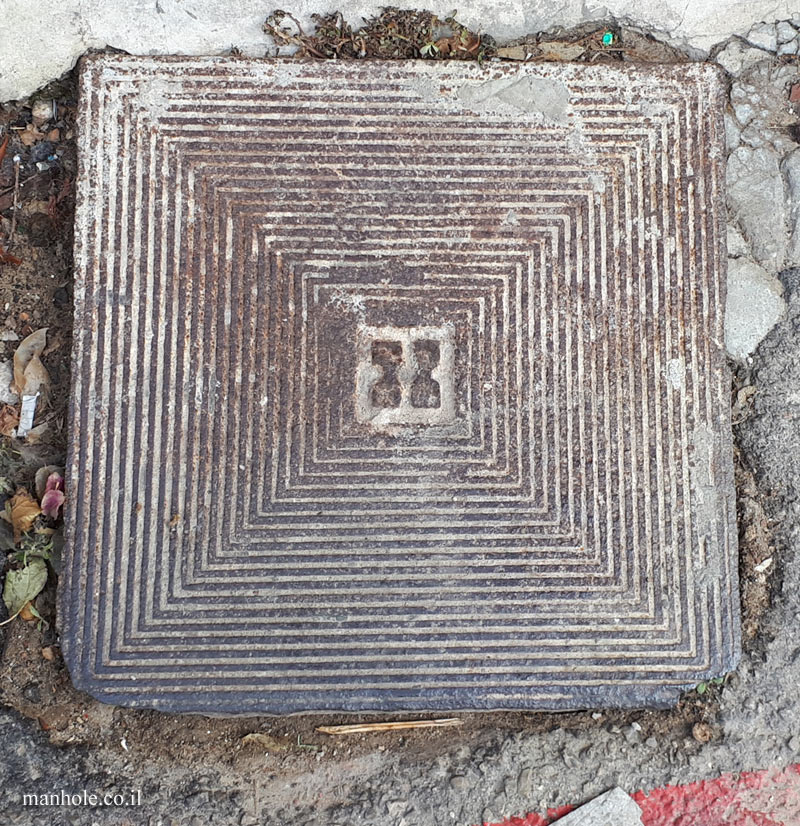 Tel Aviv - Neve Tzedek - Old sewage cover with a background of squares