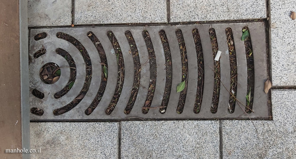 Rishon Lezion - sidewalk drainage with slots in the shape of arches and a circle