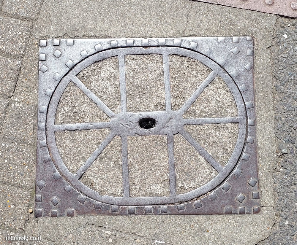 Cambridge - An elliptical concrete cover surrounded by a rectangular frame